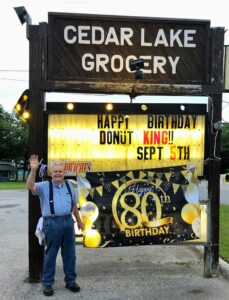 Donut King in front of Cedar Lake Grocery sign