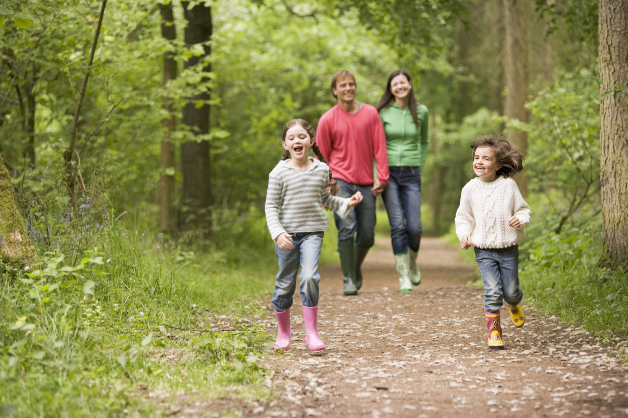 Happy family walking on a path in the woods Family walking on trail in spring
