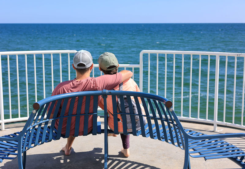 Couple sitting at end of the pier gazing over water